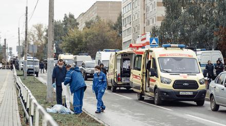 Rettungskräfte stehen nach der Tat auf einer Straße in Ischewsk. 