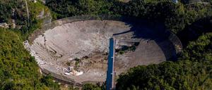 Diese Luftaufnahme zeigt die Schäden am Arecibo-Radioteleskop. Am Dienstag war die 900 Tonnen schwere Empfänger-Plattform 140 Meter tief auf die Schüssel gefallen.