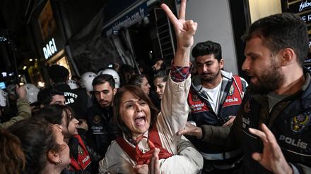 Eine Demonstrantin zeigt ein Victory-Zeichen, als sie während einer Demonstration in Istanbul am 26. Oktober 2022 von türkischen Anti-Riot-Polizisten festgehalten wird, nachdem die Vorsitzende der türkischen Ärztegewerkschaft (TTB), Sebnem Korur Fincanci, verhaftet wurde.