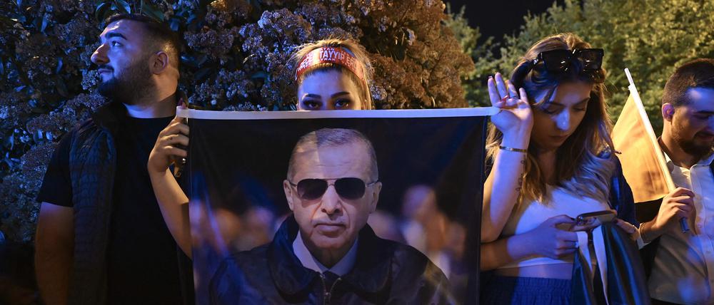 Unterstützer von Erdogan halten am Wahlabend ein Poster in Istanbul hoch.