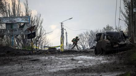 Ein ukrainischer Soldat läuft vor dem Beschuss über eine Straße in der Frontstadt Bakhmut in Deckung