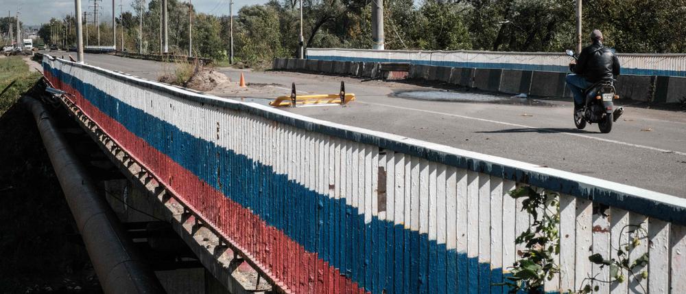 Der Zaun einer Brücke über den Fluss Oskil ist in den russischen Nationalfarben angemalt. 
