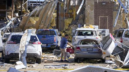 Ein Mann betrachtet ein beschädigtes Auto, nachdem ein Tornado gewütet hat. Heftige Stürme haben im Süden der USA große Schäden angerichtet und mehreren Menschen das Leben gekostet. 