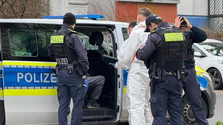  Polizeibeamte sprechen mit einem Mann der in einem Polizeifahrzeug sitzt. Ein 71-jähriger Mann ist nach dem gewaltsamen Tod seiner Ehefrau in Berlin-Hellersdorf festgenommen worden. 