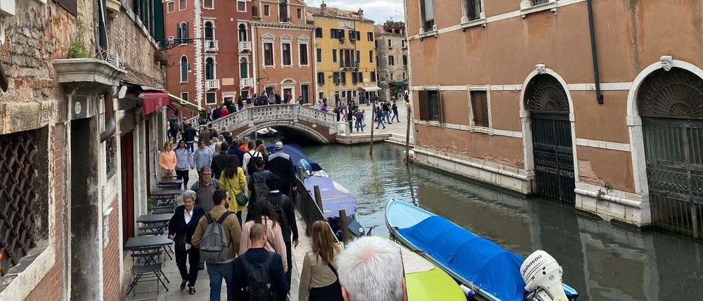 Touristen gehen in großen Gruppen durch das Stadtzentrum von Venedig.