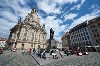 Vor dem Martin-Luther-Standbild auf dem Neumarkt in Dresden (Sachsen) rasten am Touristen, links die Frauenkirche.