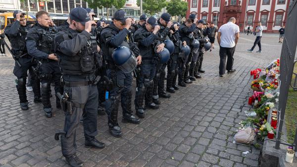 Minuten nach dem Bekanntwerden seines Todes trauern Polizisten auf dem Marktplatz in Mannheim um ihren getöteten Kollegen.  