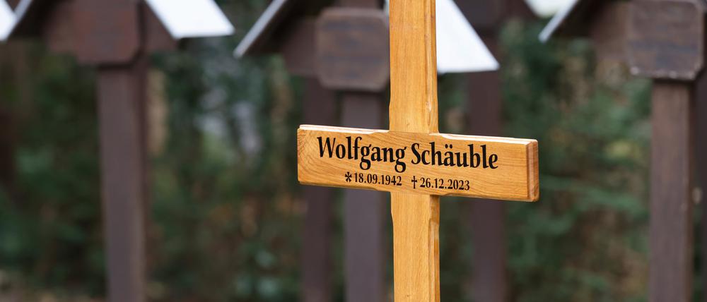 Ein Kreuz kennzeichnet am Rande der Trauerfeier für Wolfgang Schäuble die Grabstätte auf dem Friedhof.