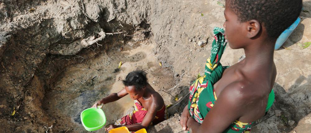 Eine Frau holt in Mosambik Wasser aus einer ungeschützten Quelle. 