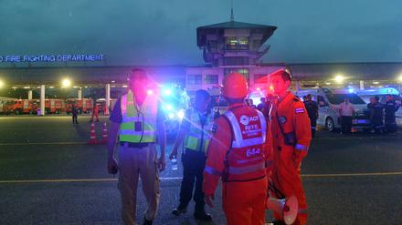 Rettungskräfte warten vor dem Suvarnabhumi Flughafen auf Passagiere.  