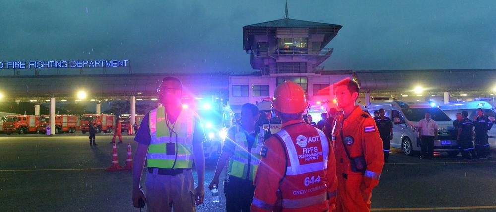 Rettungskräfte warten vor dem Suvarnabhumi Flughafen auf Passagiere.  