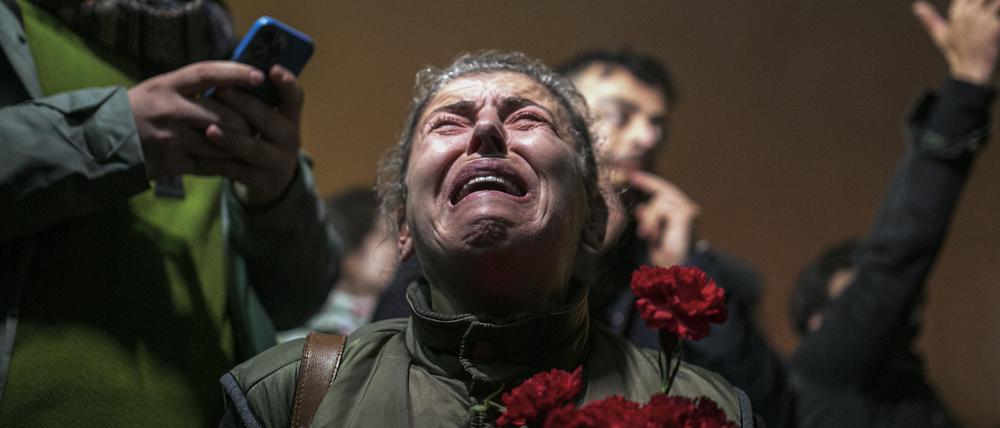 Eine Frau weint, als sie sich mit anderen zu einer Schweigeminute anlässlich des ersten Jahrestages des katastrophalen Erdbebens in der südtürkischen Stadt Antakya versammelt.