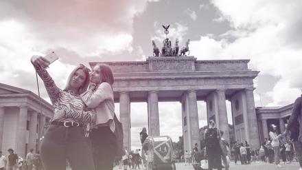 Die meisten Selfies werden Statistiken zufolge im Urlaub gemacht, hier Touristinnen am Checkpoint Charlie in Berlin.