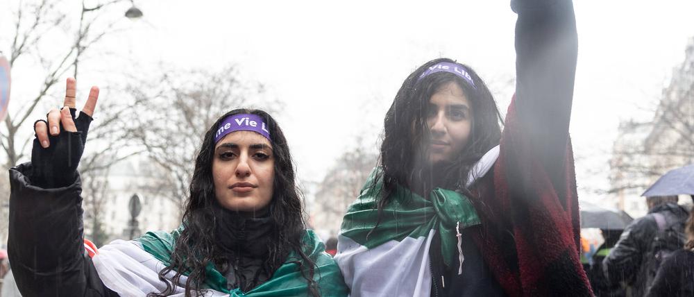 Zwei Frauen umwickelt mit der iranischen Flagge.