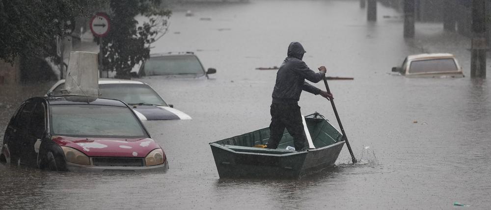 Ein Mann rudert mit einem Boot auf einer durch starke Regenfälle überfluteten Straße im brasilianischen Bundesstaat Rio Grande do Sul.