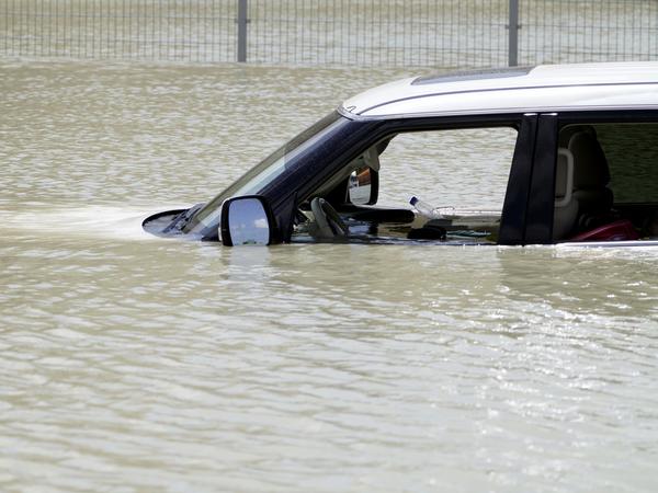 Ein Geländewagen steht im Hochwasser. Schwere Gewitter haben am Dienstag die Vereinigten Arabischen Emirate heimgesucht und Teile wichtiger Straßen überschwemmt.