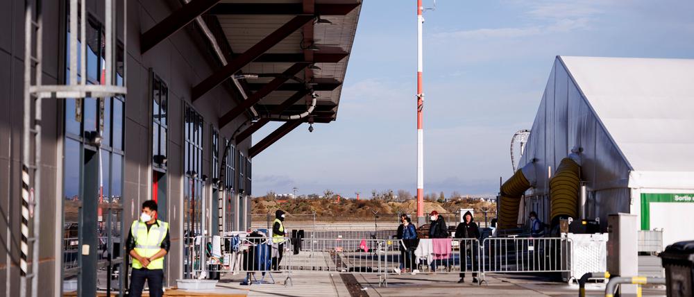 Mitarbeiter der Security stehen vor einem Unterkunftszelt für Geflüchtete im Ukraine-Ankunftszentrum Tegel, Terminal C, im ehemaligen Flughafen Tegel.