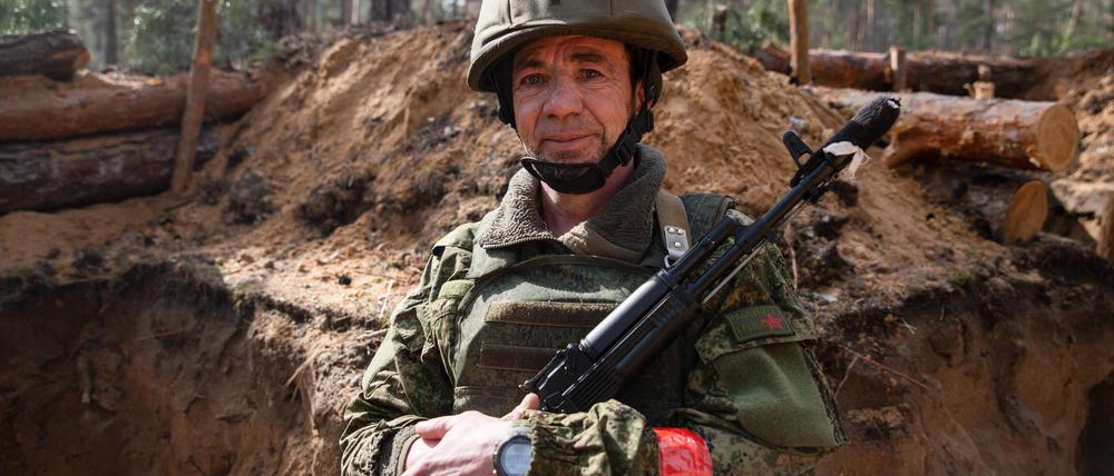 Ein russischer Soldat steht in einem Schützengraben.