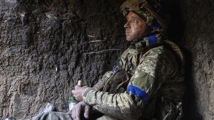 Ein ukrainischer Soldat isst in seiner Stellung in der Nähe der Frontlinie bei Bachmut ein Stück Brot. 
