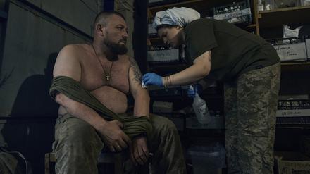 Eine Sanitäterin des Militärs behandelt einen verletzten ukrainischen Soldaten in einem Feldlazarett. 