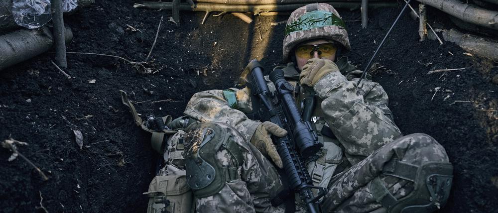 Ein ukrainischer Soldat sitzt in einem Graben in der Nähe russischer Stellungen bei Bachmut.