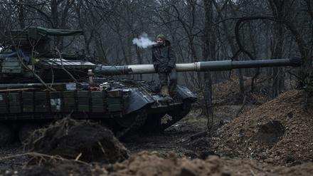 Ein ukrainischer Soldat raucht eine Zigarette oben auf einem Panzer. 