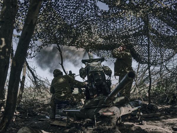 Ukrainische Soldaten feuern eine Kanone auf russische Stellungen an der Frontlinie in der Nähe von Bachmut.