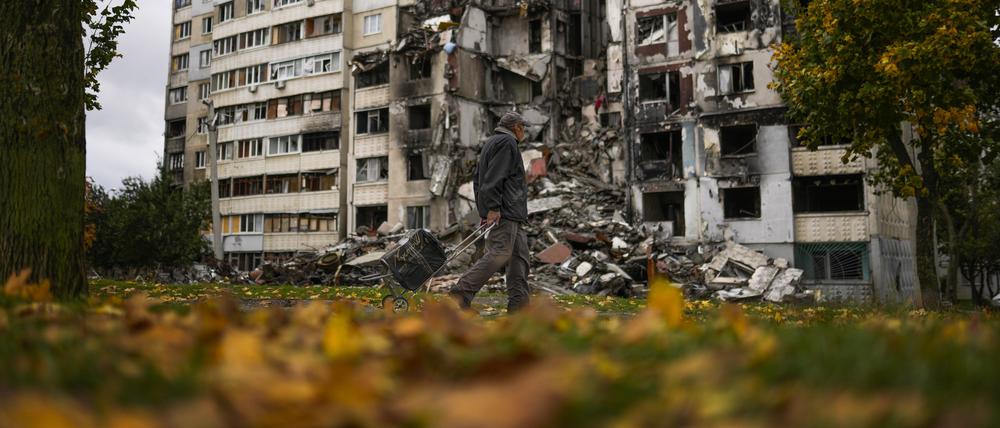 03.10.2022, Ukraine, Charkiw: Ein Mann geht an einem teilweise zerstörten Wohnhaus im Stadtteil Saltiwka vorbei. Foto: Francisco Seco/AP/dpa +++ dpa-Bildfunk +++