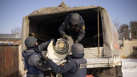Ukrainische Rettungskräfte schieben die Überreste einer von den russischen Streitkräften abgefeuerten S-300-Rakete auf einen Lastwagen. 