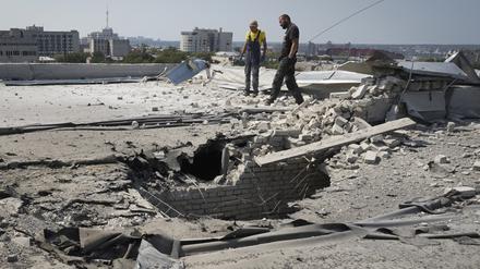 Kommunale Mitarbeiter arbeiten auf einem Dach, das bei einem russischen Angriff beschädigt wurde.