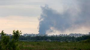 Nach dem Beschuss durch russische Truppen steigt eine Rauchsäule hinter Wohnhäusern auf. 