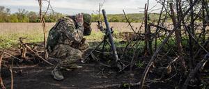 Ein Soldat einer Mörser-Einheit der ukrainischen Streitkräfte hält sich die Ohren zu.