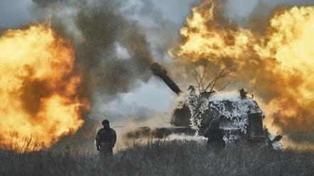 Ukrainische Soldaten stehen vor einem selbstfahrenden Artilleriefahrzeug.