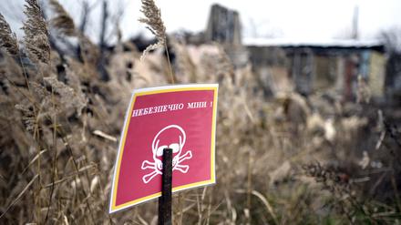 Ein Schild mit der Aufschrift „Minengefahr“ ist in der Region Charkiw im Nordosten der Ukraine zu sehen. 
