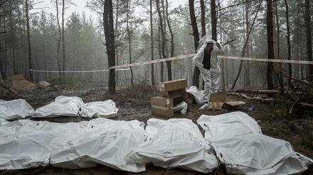 Säcke mit Leichen sind während der Exhumierung im kürzlich zurückeroberten Gebiet von Isjum, zu sehen. 