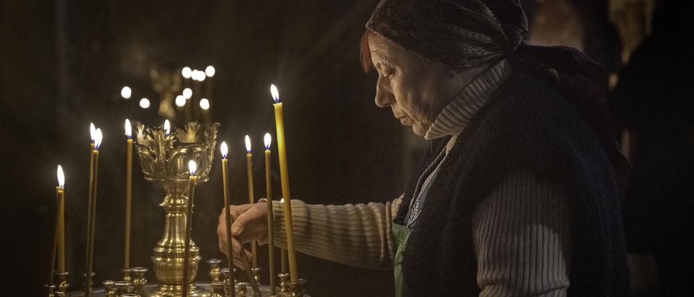 Eine Frau zündet Kerzen an