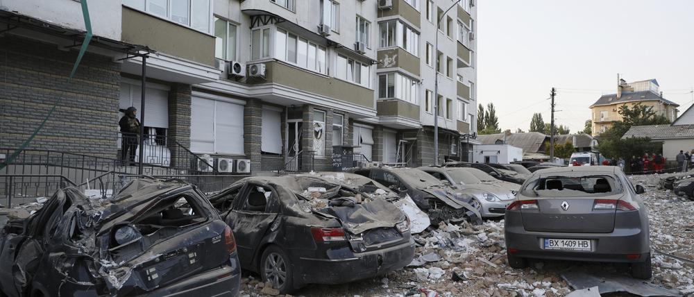 Ein Polizist auf einem Parkplatz mit beschädigten Autos vor einem Wohnhaus, das bei einem russischen Angriff in Kiew am Dienstag beschädigt wurde. Nun gab es einen erneuten Angriff.
