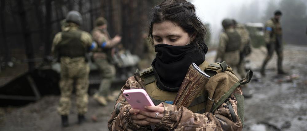 Die ukrainische Soldatin Dascha (22) überprüft ihr Telefon. 