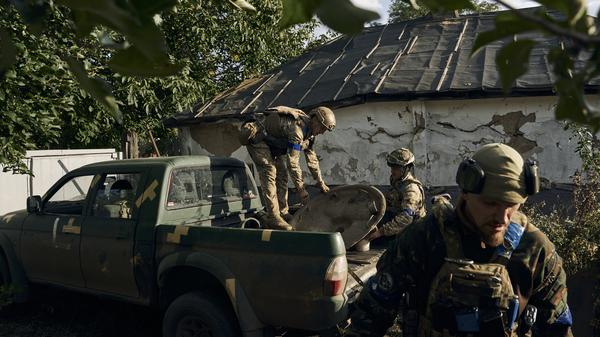 Ukrainische Soldaten entladen Waffenteile in der kürzlich zurückeroberten Stadt Kupjansk.