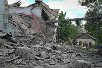 Eine Frau geht an einem zerstörten Gebäude in Lyssytschansk vorbei.