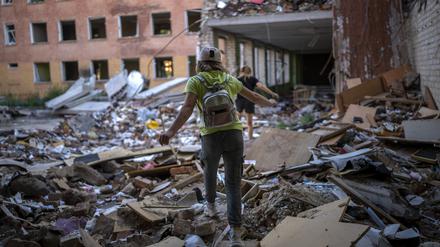 Eine ukrainische Schülerin geht auf den Trümmern in die Schule.