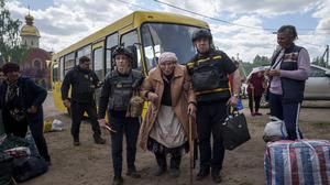 Rettungskräfte helfen der 88-Jährigen Liudmila Kalashnik (M) nach der Evakuierung aus Wowtschansk.
