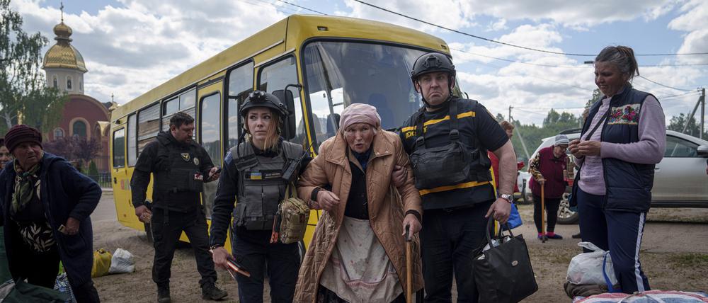 Rettungskräfte helfen der 88-Jährigen Liudmila Kalashnik (M) nach der Evakuierung aus Wowtschansk.