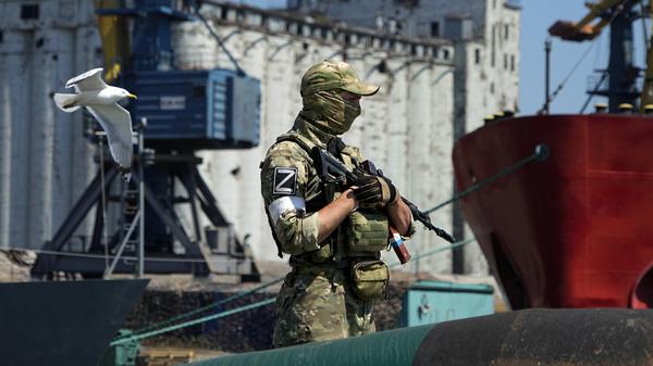 Ein russischer Soldat im ukrainischen Mariupol bewacht einen Pier mit einem Getreidespeicher. 