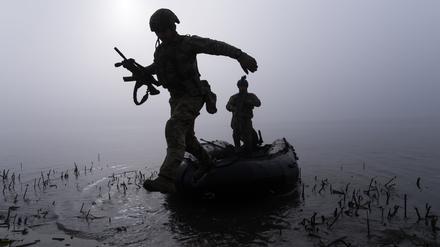 Ein ukrainischer Soldat springt am Ufer des Dnipro-Flusses an der Frontlinie nahe Cherson aus dem Boot (Symbolfoto).