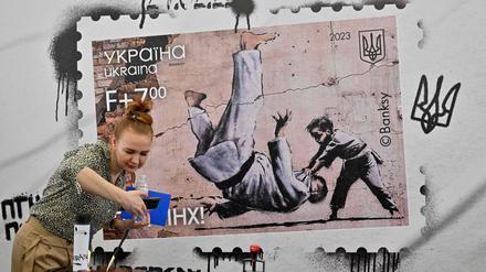 Widerstand steckt in der kleinsten Geste. Eine Ukrainerin fotografiert in Kiew Banksys jüngsten Streich.