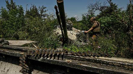Ein ukrainischer Soldat inspiziert einen zerstörten russischen BMP-3-Panzer in der Region Saporischschja, am 21. Juli 2023. Wenige Tage später haben ukrainische Truppen offenbar einen BMP-1-Panzer unbemannt über ein Minenfeld geschickt. 