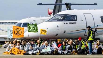 Mitglieder verschiedener Umweltvereine führen die Protestaktion „SOS für das Klima“ am Flughafen Schiphol in Amsterdam (Niederlande) durch. 