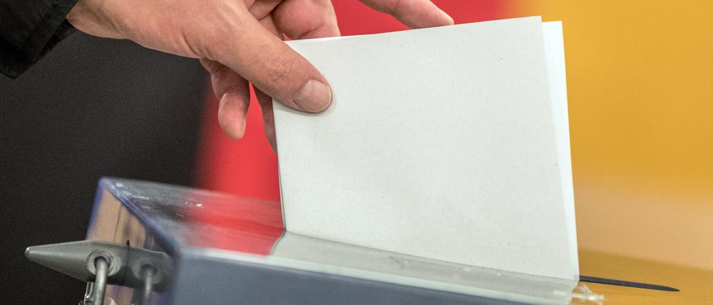 Ein Wähler wirft einen Stimmzettel in die Wahlurne.