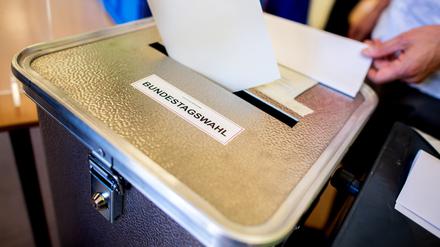 Ein Wähler wirft in einem Berliner Wahllokal seinen Stimmzettel in eine Wahlurne. 